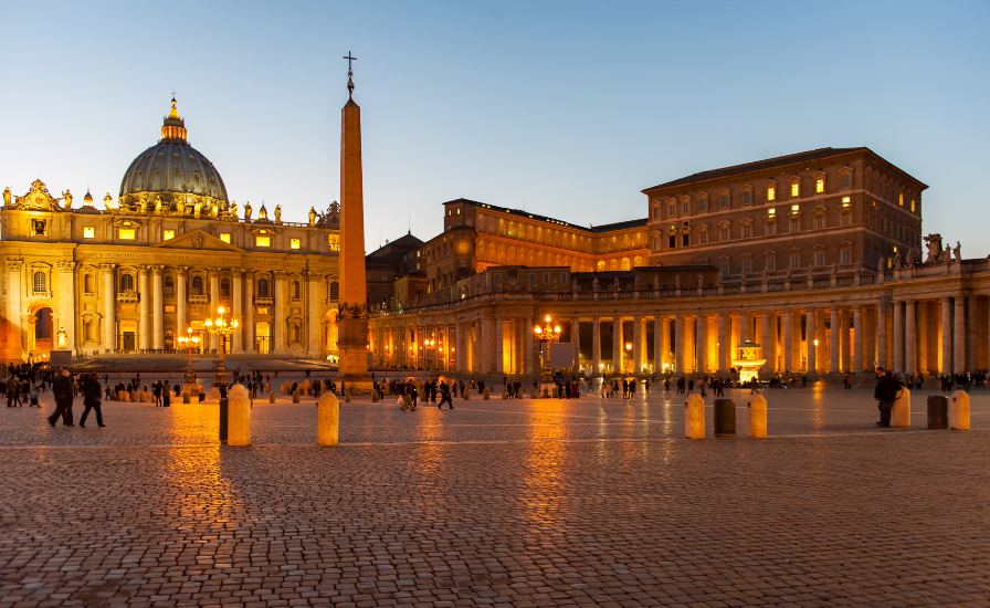 St. Peter's Basilica in Vatican City, illuminated at dusk, showcasing its stunning architectural beauty


