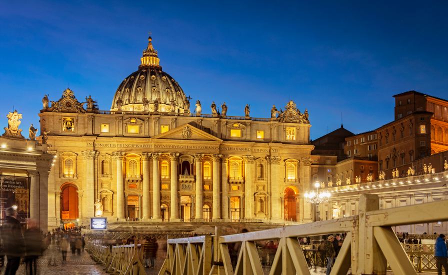A stunning view of the Vatican City at dusk with the iconic St. Peter's Basilica in the background.