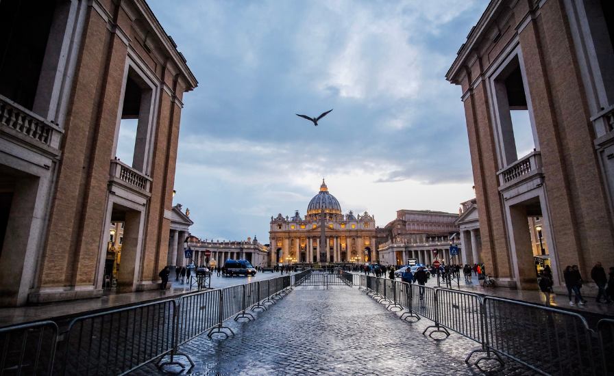 A-bird-soars-above-the entrance to the Vatican,with St. Peter's Basilica standing tall in the background