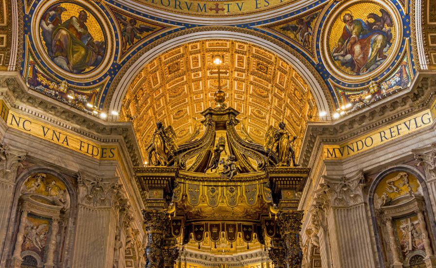 Ornate gold and blue paintings on church ceiling, Altar of St. Peter's Basilica visible