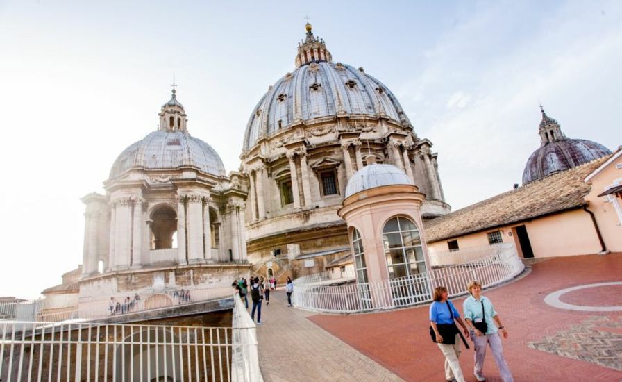 Tourists walking along in Rome, with St.Peter's Dome Tickets available.